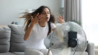 Persona con calor frente a un ventilador. Persona con calor frente a un ventilador.