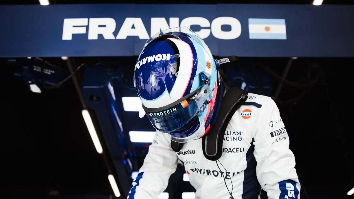 Franco Colapinto saliendo del FW46 con la bandera argentina de fondo.