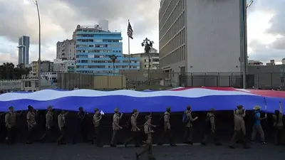 FOTO DE ARCHIVO-Soldados portan una bandera cubana frente a la embajada estadounidense en La Habana. FOTO DE ARCHIVO-Soldados portan una bandera cubana frente a la embajada estadounidense en La Habana.