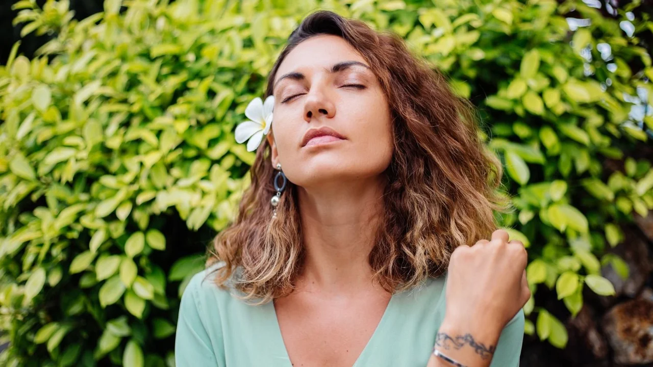 Una mujer disfrutando los aromas del aire. 