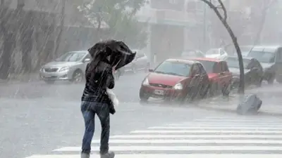 Una persona bajo la lluvia Una persona bajo la lluvia