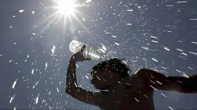 Una persona mojándose la cabeza bajo el sol Una persona mojándose la cabeza bajo el sol