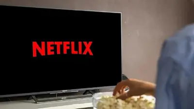TElevisor con Netflix y persona come pochoclos. TElevisor con Netflix y persona come pochoclos.