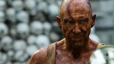 Ralph Fiennes con sangre y cráneos detrás. Ralph Fiennes con sangre y cráneos detrás.