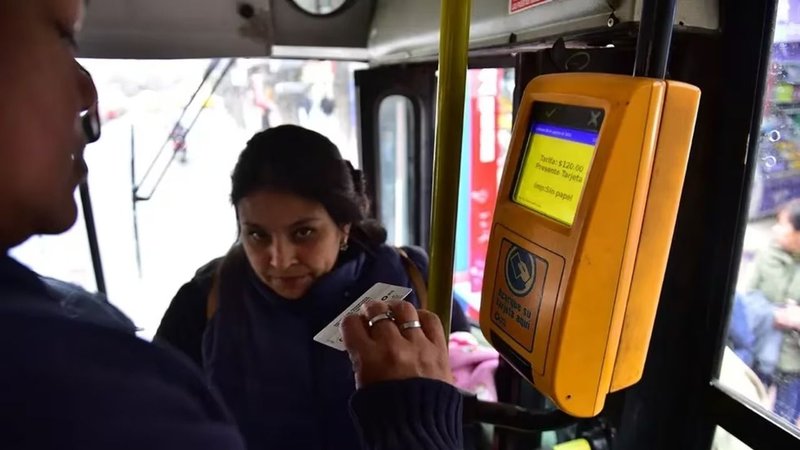 Una persona pagando el boleto de colectivo