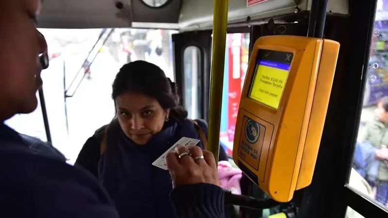 Una persona pagando el boleto de colectivo