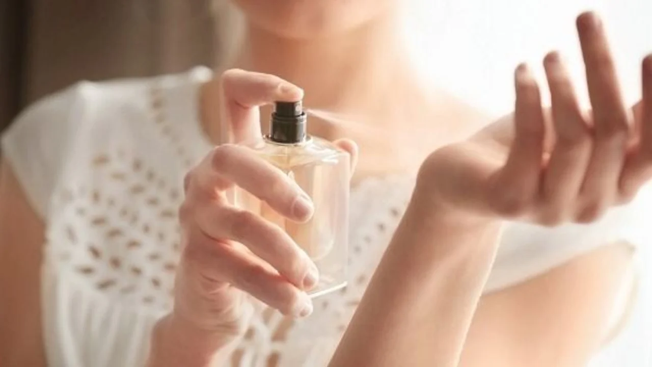 mujer probandose un perfume.