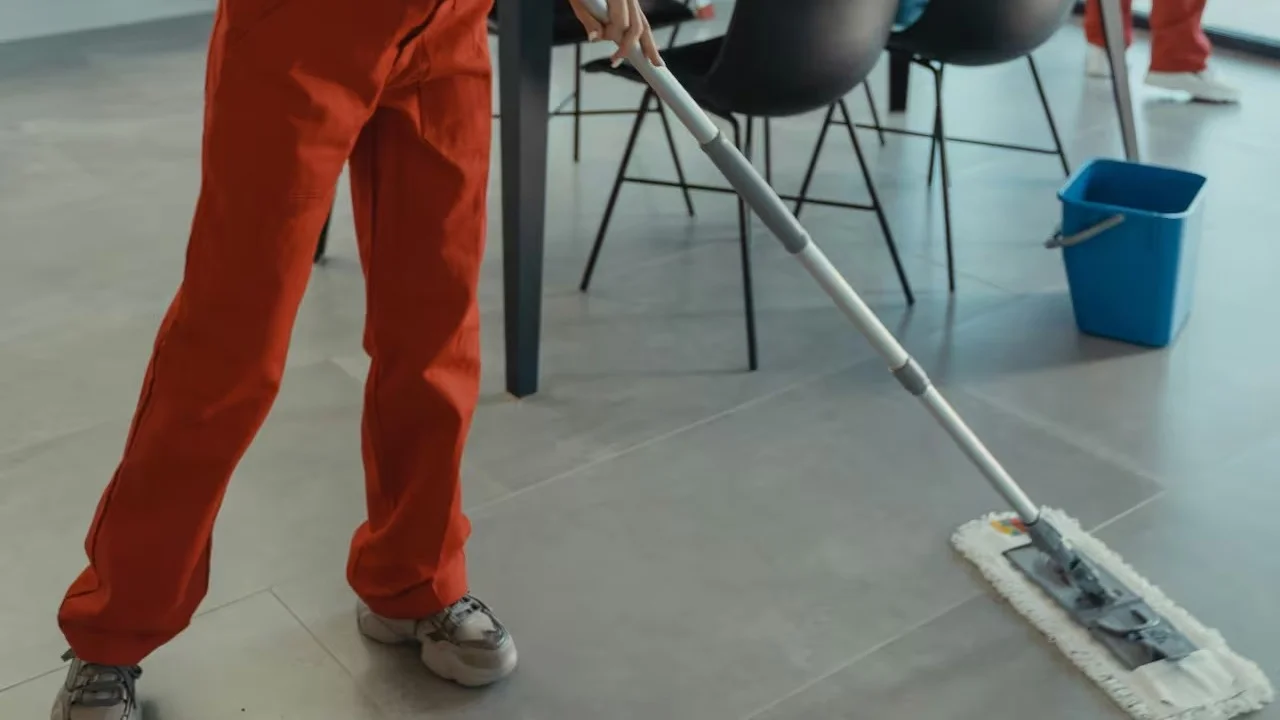 Persona pasando el trapo de piso.