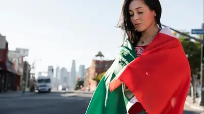 Mujer envuelta en bandera de México en ciudad urbana representando el Mundial 2026 Mujer envuelta en bandera de México en ciudad urbana representando el Mundial 2026