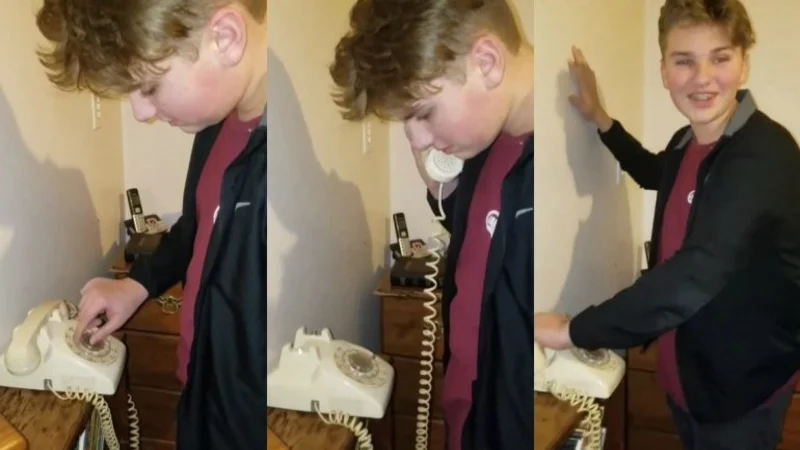 Un adolescente intenta utilizar un teléfono de disco, pero no sabe cómo