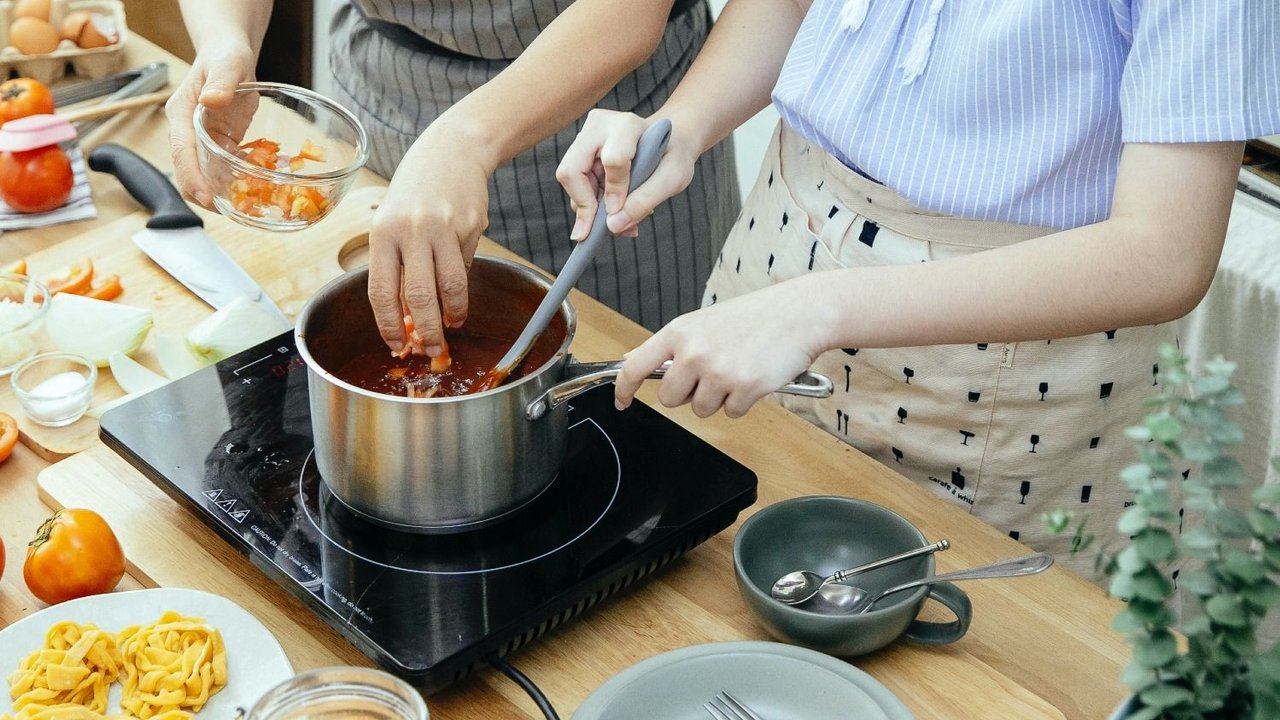 dos mujeres cocinando salsa
