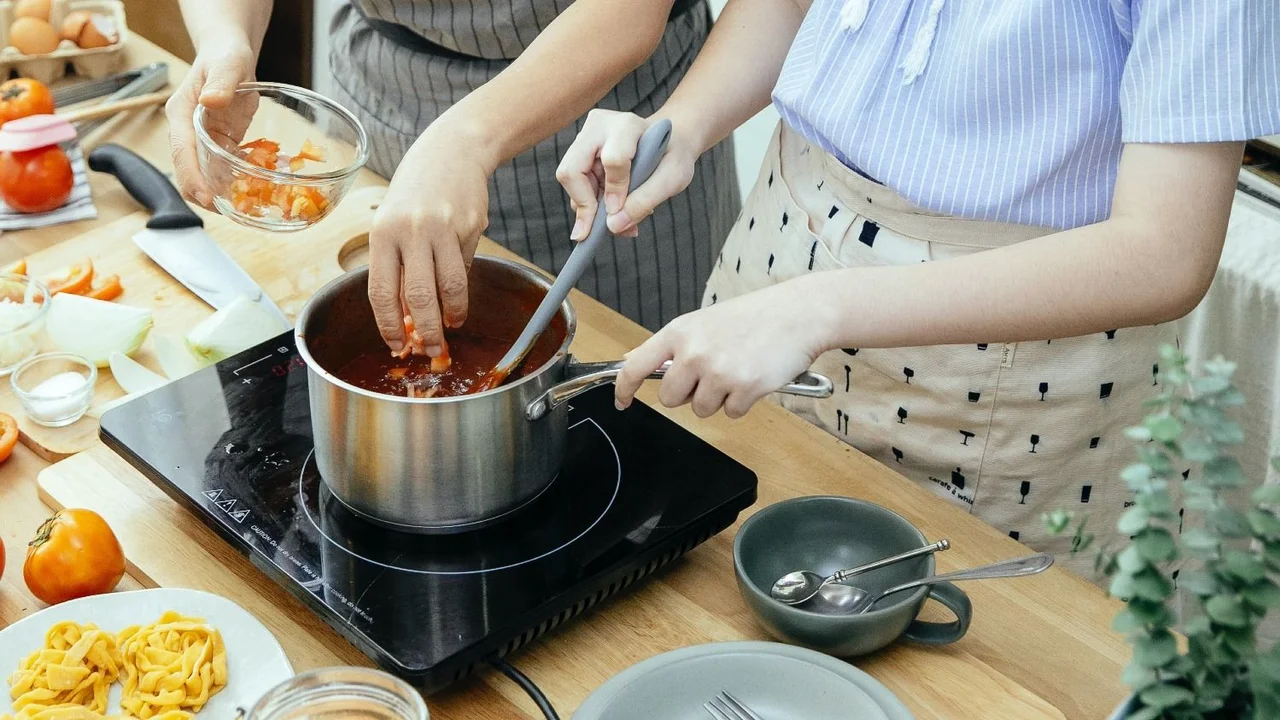 dos mujeres cocinando salsa