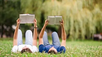 Pareja leyendo acostada en el cesped. Pareja leyendo acostada en el cesped.