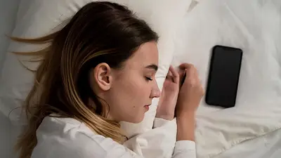 Una mujer durmiendo con el celular a su lado Una mujer durmiendo con el celular a su lado