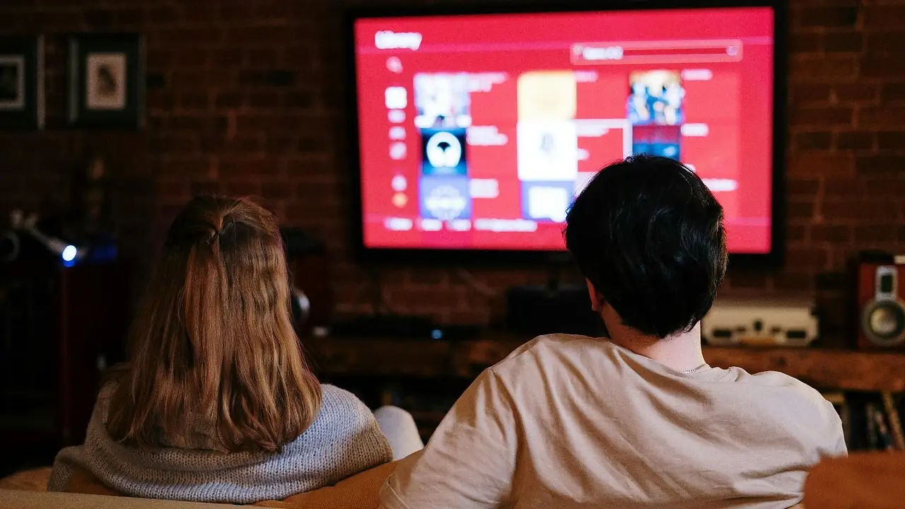 Pareja ve televisor en su living
