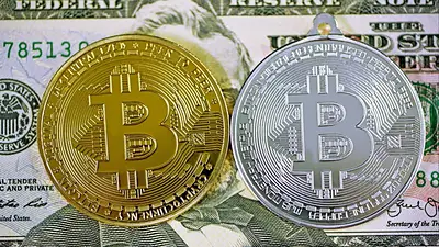 Monedas de bitcoin sobre un billete de dólar estadounidense Monedas de bitcoin sobre un billete de dólar estadounidense