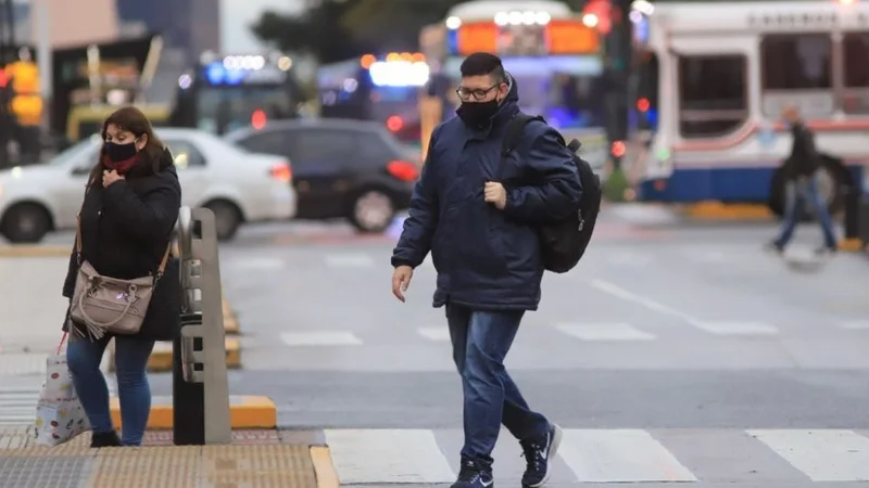 Clima en Buenos Aires, un hombre y una mujer caminan con abrigo por el frío