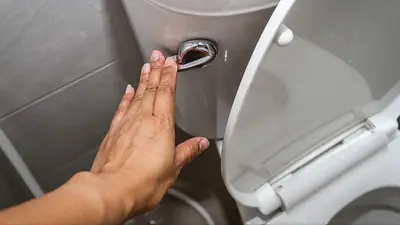 Una persona tirando la cadena del inodoro Una persona tirando la cadena del inodoro
