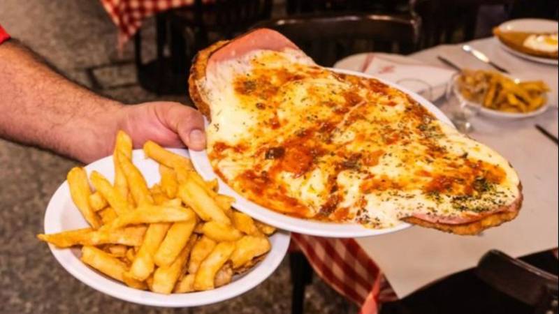Clásico plato de milanesa napolitana que se sirve en los bodegones 