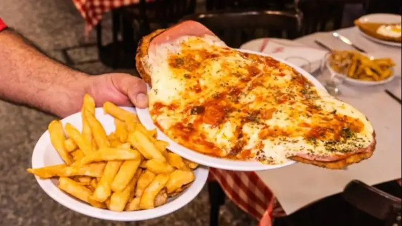 Clásico plato de milanesa napolitana que se sirve en los bodegones 