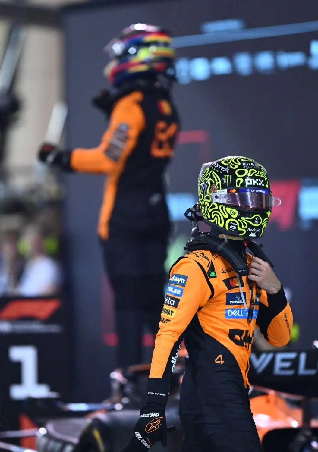 Oscar Piastri festejando su triunfo a espaldas de Lando Norris.