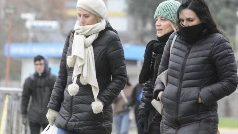 Personas abrigadas caminando por la calle