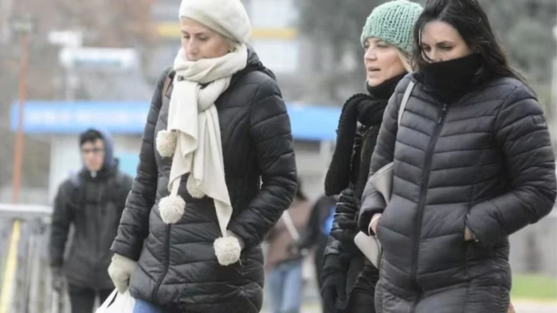 Personas abrigadas caminando por la calle