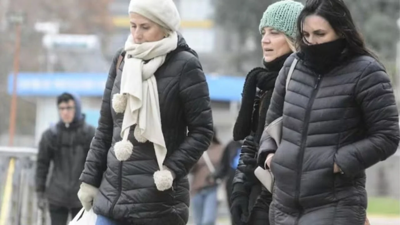 Personas abrigadas caminando por la calle