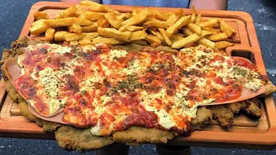 Milanesa napolitana con papas fritas. Milanesa napolitana con papas fritas.