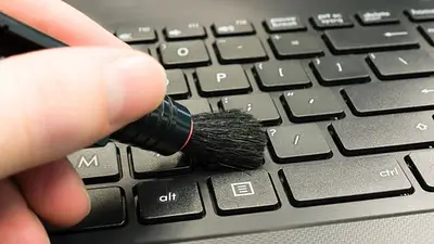 Usuario limpiando el teclado de su computadora Usuario limpiando el teclado de su computadora