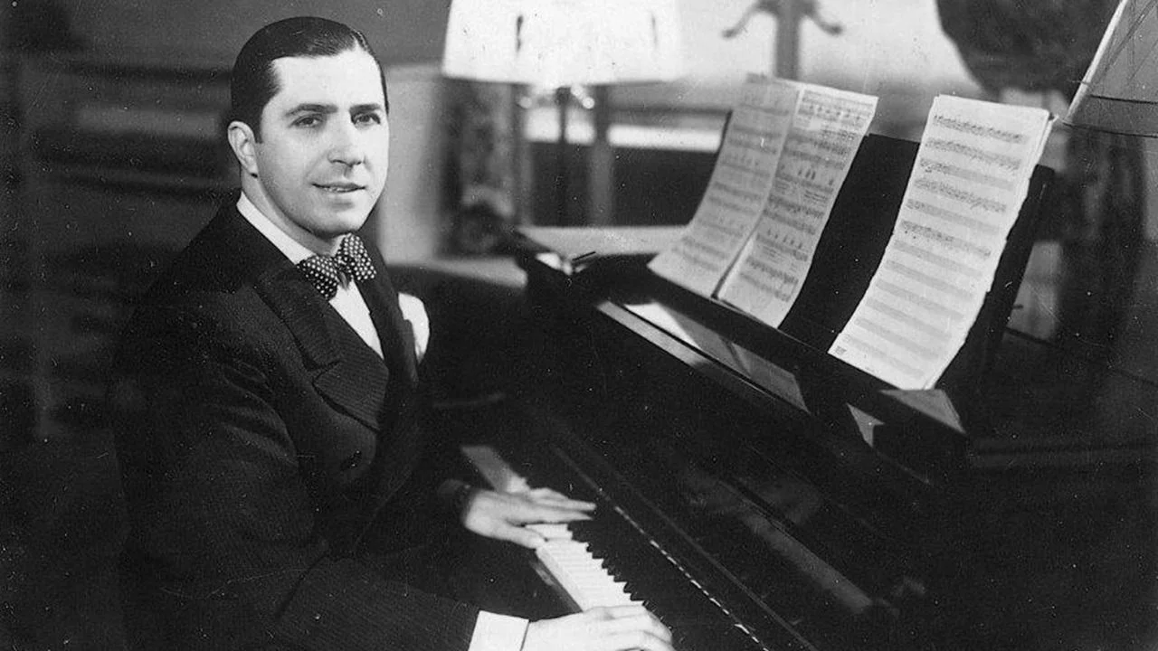 Carlos Gardel sentado en un piano