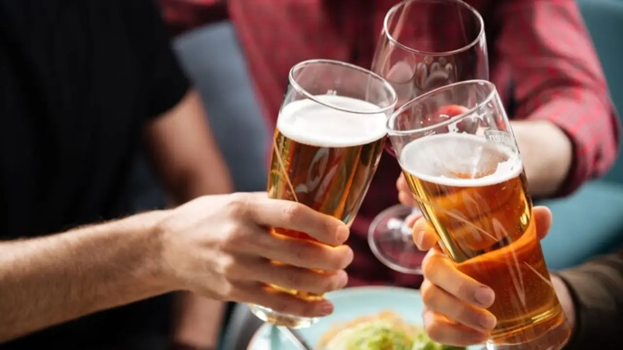 Personas brindando con cerveza.