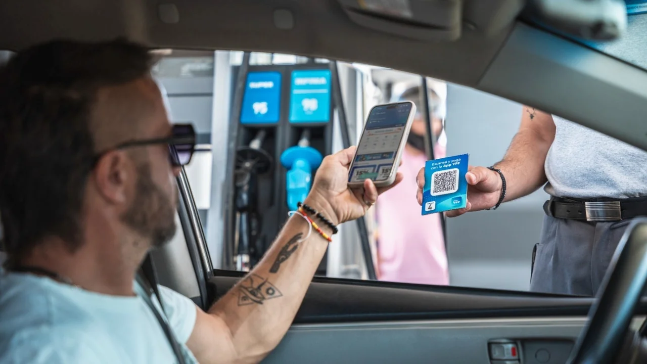Hombre escanea el QR de YPF para pagar desde su celular en una estación de servicio