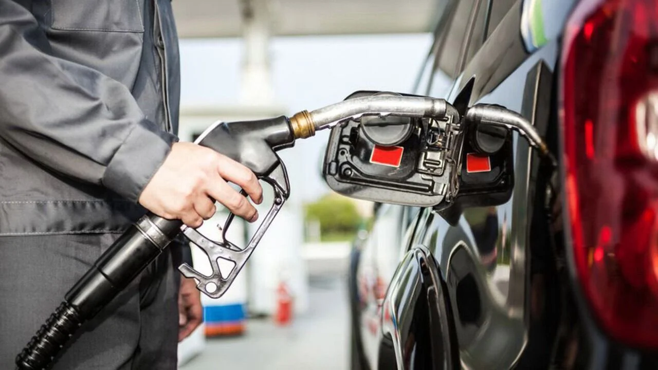 Una persona cargando combustible al auto