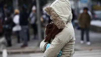 Una persona muy abrigada en la calle Una persona muy abrigada en la calle