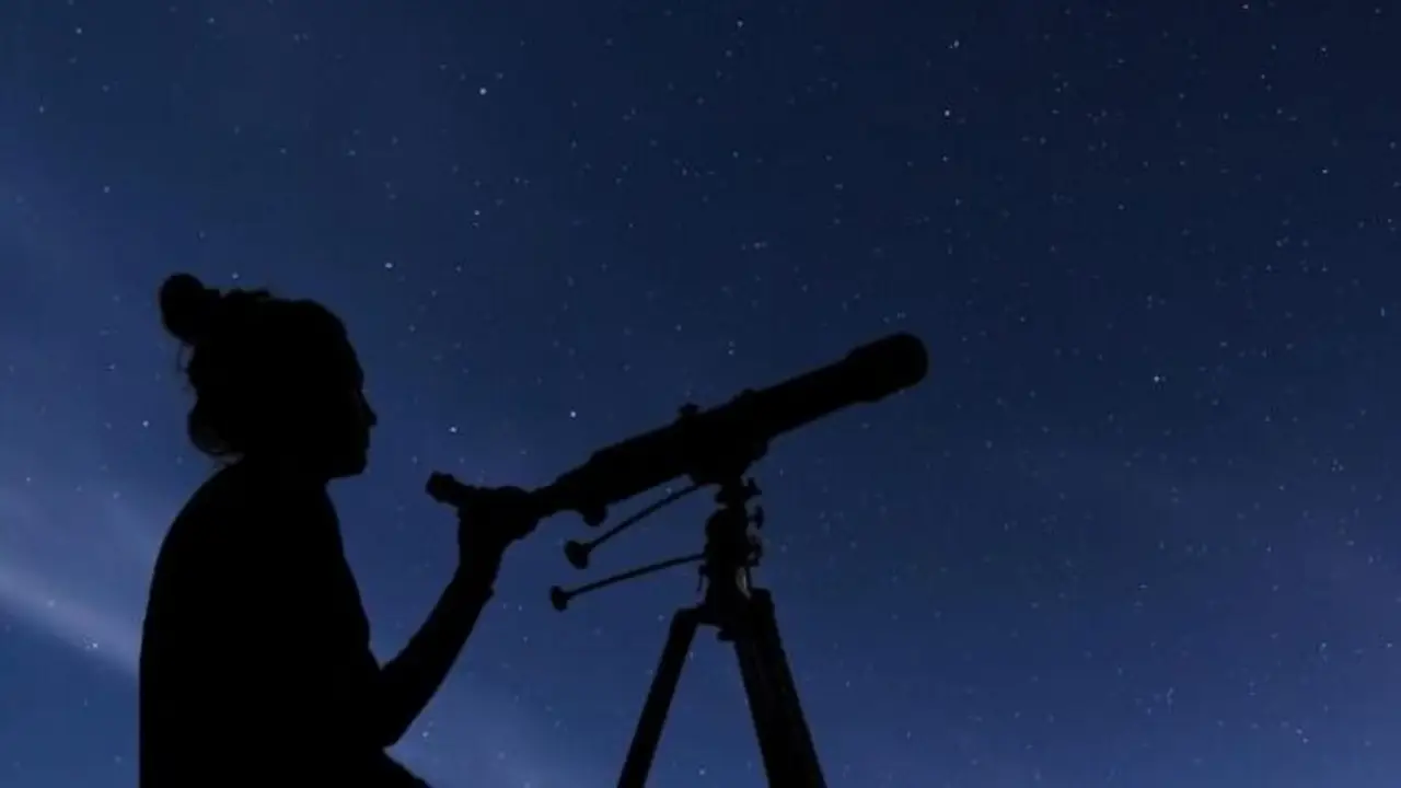 mujer observa telescopio.