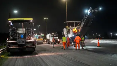 Obreros trabajando con máquinas en la autopista Obreros trabajando con máquinas en la autopista