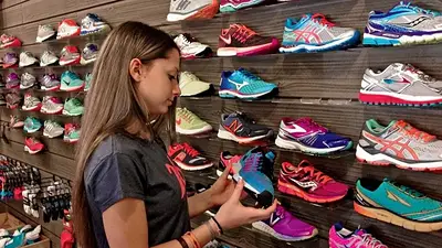 Consumidora mirando zapatillas para comprar en un outlet Consumidora mirando zapatillas para comprar en un outlet
