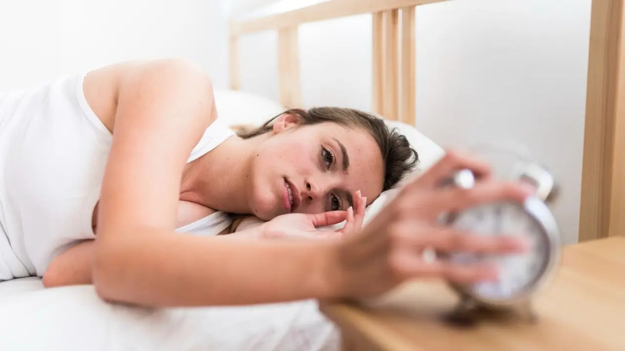 Una mujer apagando el despertador