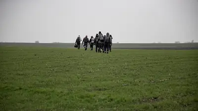 FOTO DE ARCHIVO: Un grupo de personas camina por un campo cerca del pueblo de Majdan FOTO DE ARCHIVO: Un grupo de personas camina por un campo cerca del pueblo de Majdan