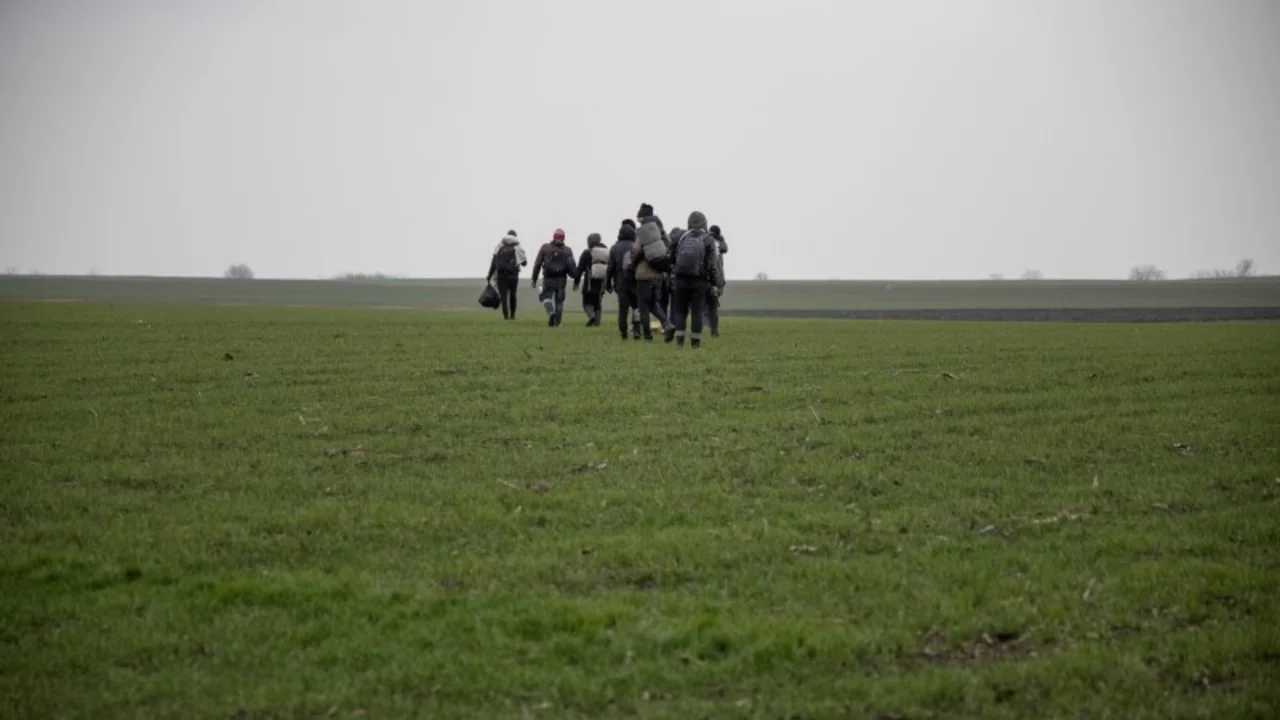 FOTO DE ARCHIVO: Un grupo de personas camina por un campo cerca del pueblo de Majdan