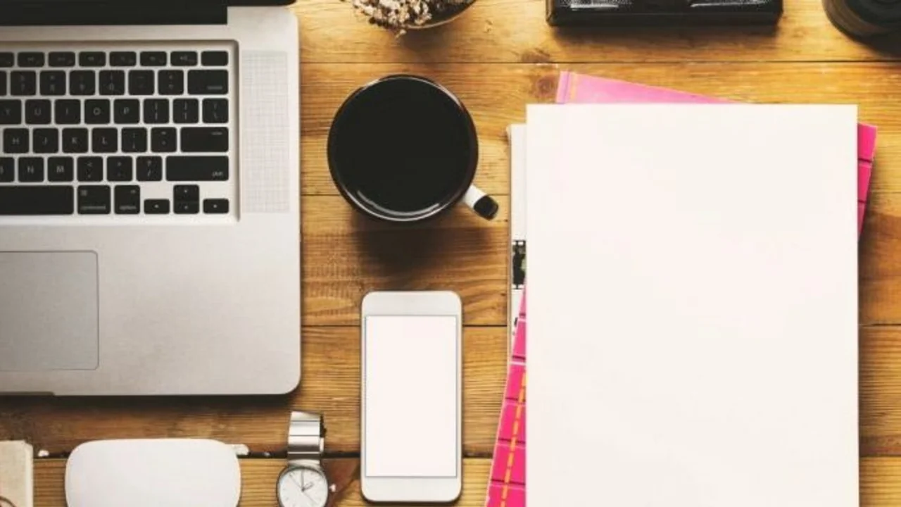 Laptop, café y papel para escribir: trabajo en escritorio