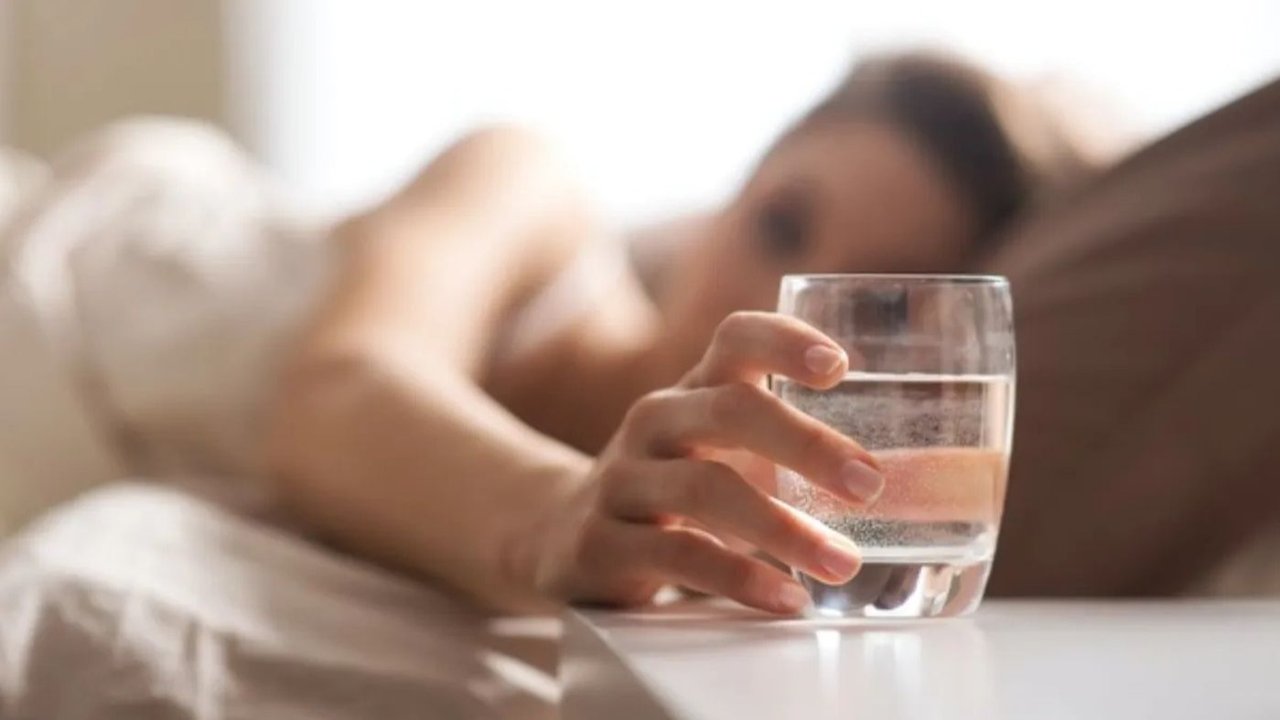 Mujer agarrando vaso.