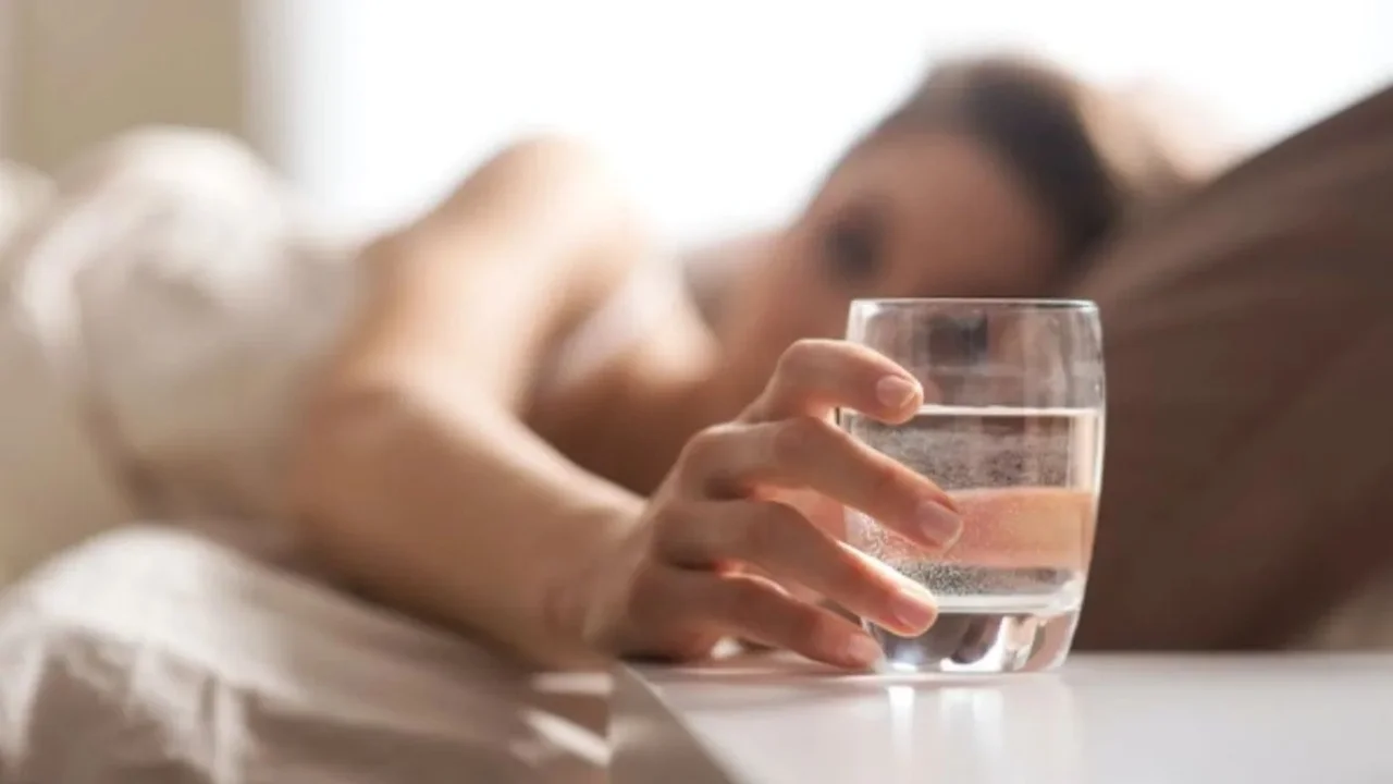 Mujer agarrando vaso.