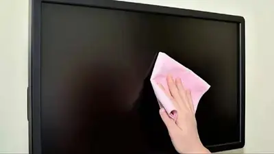 Una persona limpiando la pantalla de un televisor Una persona limpiando la pantalla de un televisor