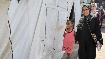 Una madre intenta evitar que su hija vea las heridas de su cabeza en la destrozada Gaza Una madre intenta evitar que su hija vea las heridas de su cabeza en la destrozada Gaza