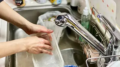 Persona lavando platos. Persona lavando platos.