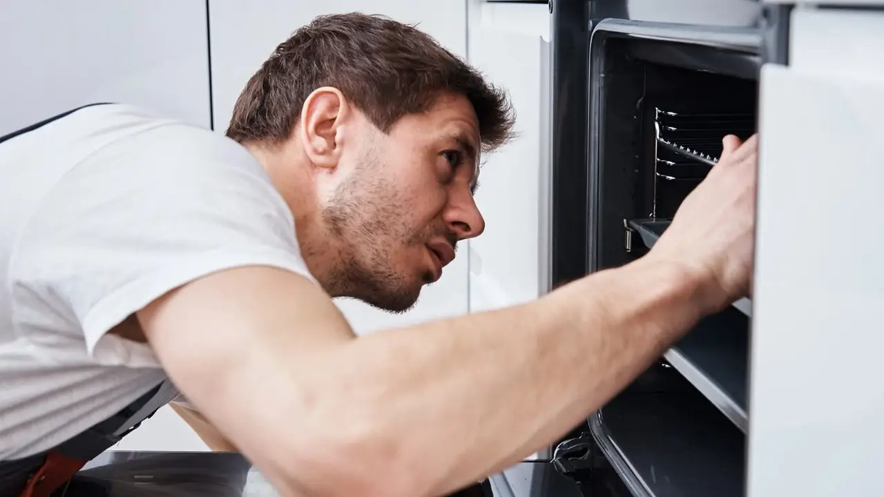 Un nombre abriendo la un horno