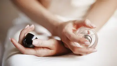 Una mujer poniéndose perfume Una mujer poniéndose perfume