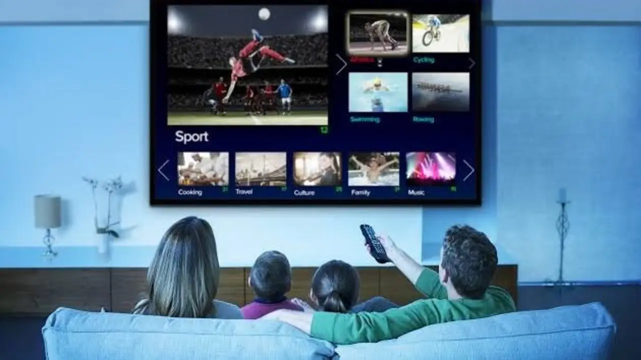 Familia ve televisión en su livin